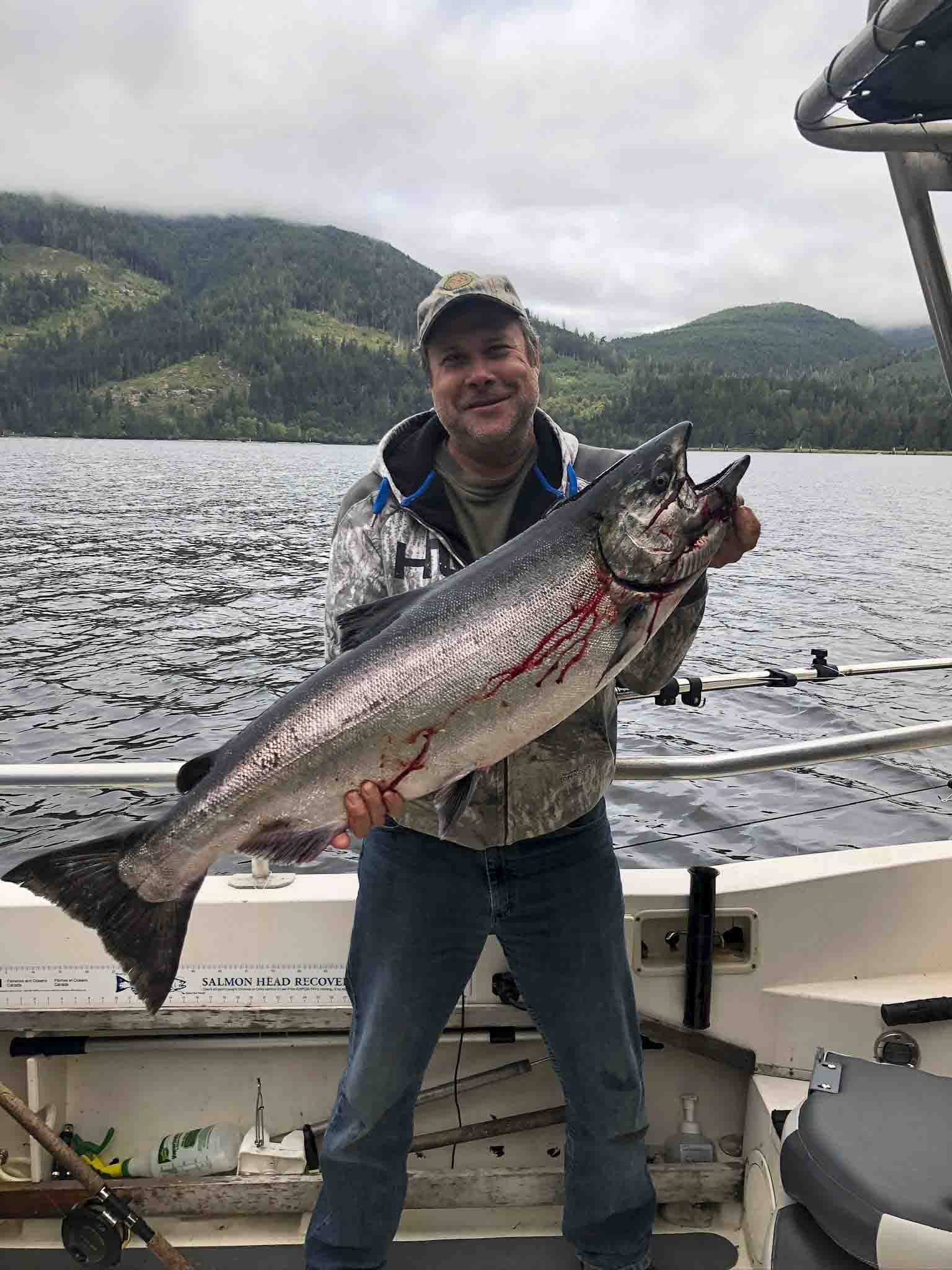 a person holding a fish on a boat