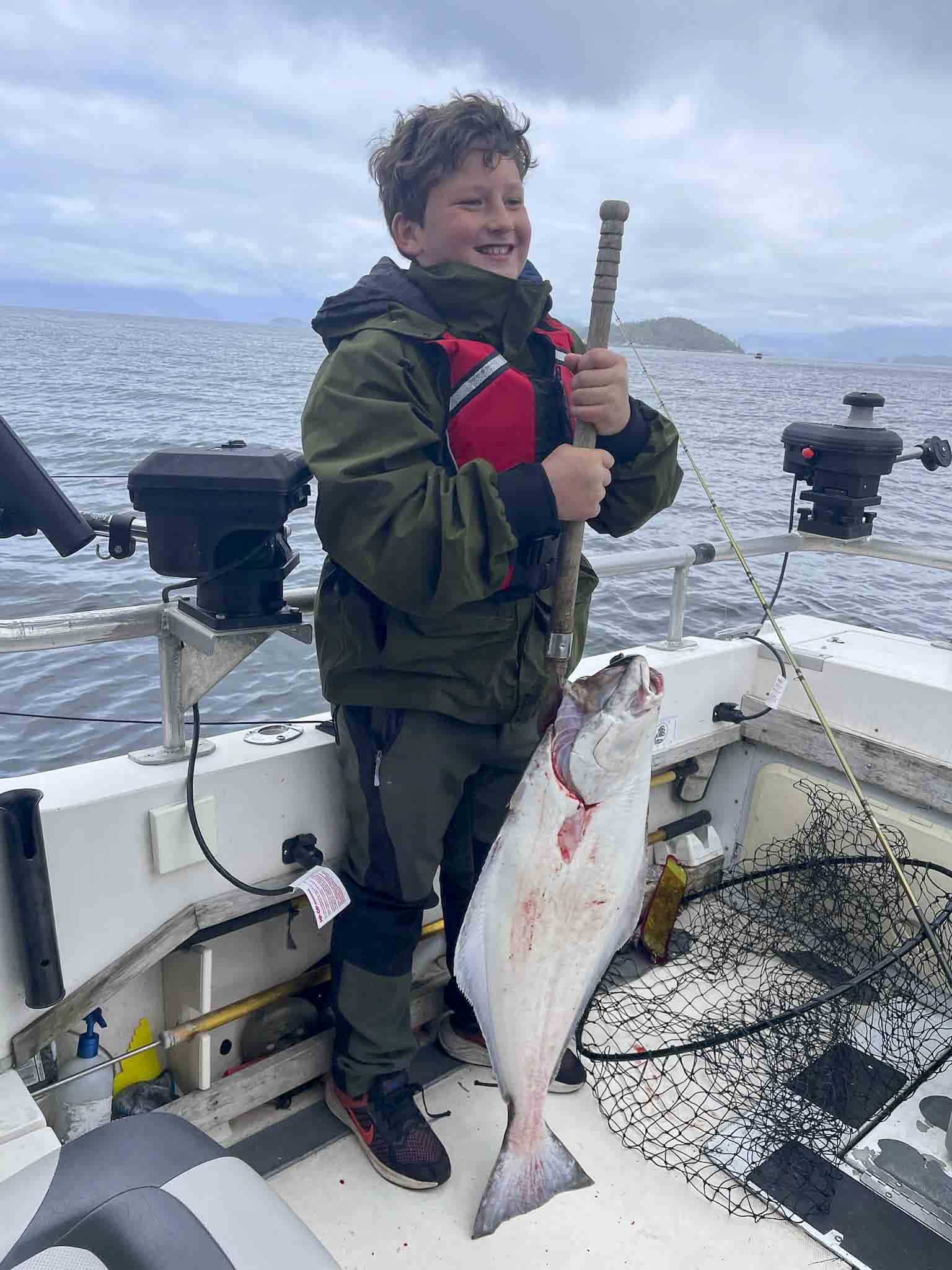 a child holding a fish on a boat